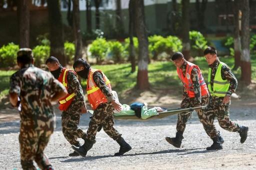Des militaires népalais transportent une personne secourue, le 28 août 2026, à la suite des coulées de boue survenues à la frontière sino-népalaise l'avant veille — PRABIN RANABHAT / AFP