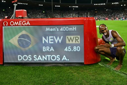 Alison Dos Santos posa con el marcador electrónico que muestra su récord del mundo (45.80) de los 400 metros vallas tras ganar la reunión de Zurich (Suiza) de la Liga de Diamante, el 27 de agosto de 2026 — Fabrice COFFRINI / AFP
