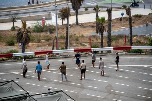 Des migrants jouent au foot sur un parking près d'abris temporaires installés pour eux, le 27 août 2026 à Ceuta — Antonio Sempere / AFP