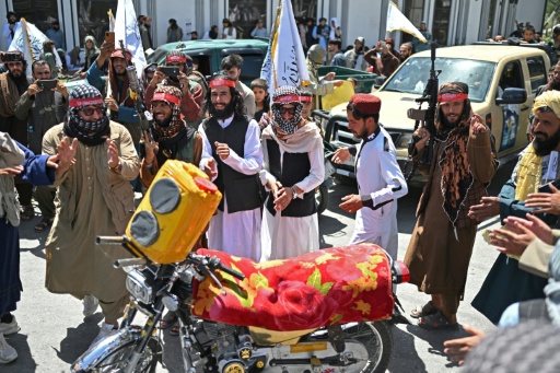 Des membres de forces de sécurité talibanes dansent autour d'une moto lors des célébrations des cinq ans du retour au pouvoir en Afghanistan de ce mouvement ultra-rigoriste, le 15 août 2026 à Kaboul — Wakil KOHSAR / AFP