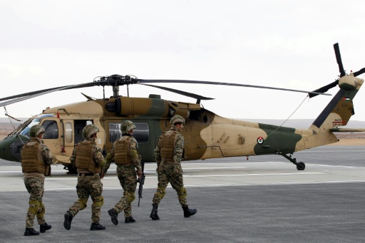 Varios militares pasan frente a un helicóptero estadounidense Black Hawk entregado al ejército jordano, el 28 de enero de 2018 en la base aérea Rey Abdalá II, en Zarqa, al norte de Jordania — . / AFP