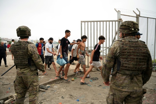 Soldiers watching as migrants cross back into Morocco — JORGE GUERRERO / AFP
