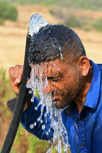 رجل يبرّد نفسه بالماء في يوم حار قرب بنزرت (شمال) في 21 تموز/يوليو 2026. — فتحي بلعيد