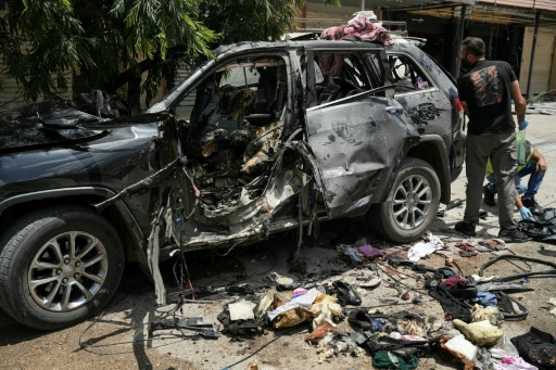 First responders inspect the wreckage of a car reportedly targeted by an Israeli strike in Nabatieh in southern Lebanon
