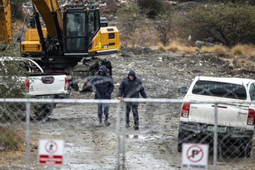 Des agents de la police sud-africaine (SAPS) marchent aux abords d'un puits de mine à Nkaneng, près de Marikana, où 14 mineurs clandestins ont été retrouvés morts, des opérations de secours sont en cours — EMMANUEL CROSET / AFP