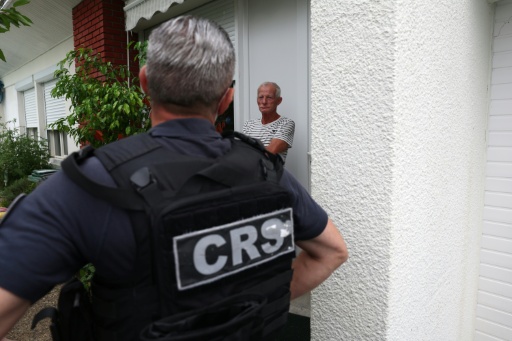 Un CRS discute avec un habitant de la commune de Saint-Médard-en-Jalles, près de Bordeaux, où un ordre d'évacuation a été émis en raison des feux de forêts, le 25 juillet 2026 — ROMAIN PERROCHEAU / AFP