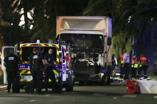 Des policiers et des secouristes  près d'un camion qui a foncé dans la foule venue voir le feu d'artifice sur la Promenade des Anglais à Nice, le 14 juillet 2016