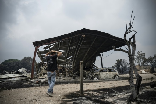 Un habitant inspecte les dégâts dans une zone résidentielle brûlée après un incendie de forêt à Le Porge, dans le département de la Gironde, dans le sud-ouest de la France, le 25 juillet 2026 — JULIEN DE ROSA / AFP
