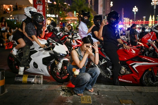 Une femme se préparant avant de participer à une séance photo et vidéo de moto à Chongqing, dans le sud-ouest de la Chine, le 20 juillet 2026. — WANG Zhao / AFP