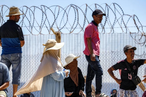 Des personnes attendent derrière une clôture surmontée de barbelés le retour de proches ayant tenté de franchir la frontière pour entrer dans l’enclave espagnole de Ceuta, le 2 août 2026 à Fnideq — Abdel Majid BZIOUAT / AFP