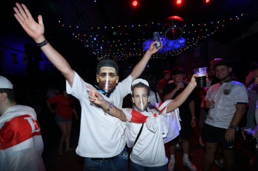 Torcedores ingleses usam máscaras de Bellingham e Harry Kane antes da partida das quartas de final entre Inglaterra e Noruega no Camp and Furnace, em Liverpool, no dia 11 de julho de 2026 — PETER POWELL / AFP