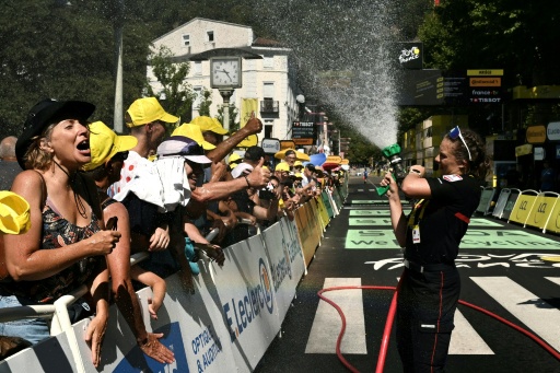 Une femme pompier arroser les spectateurs à l'arrivée de la 4e étape du Tour de France, le 7 juillet 2026 à Foix