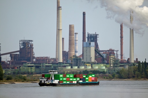 A container ship on the Rhine sails past Thyssenkrupp Steel Europe AG in Duisburg — Ina FASSBENDER / AFP