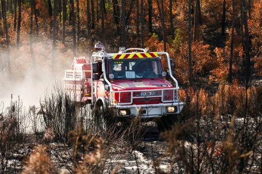 Un camion de pompiers au milieu d'une végétation en partie détruite par un incendie à Lège-Cap-Ferret, en Gironde, le 1er août 2026 — ROMAIN PERROCHEAU / AFP