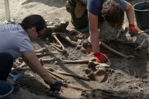 Des archéologues exhument des restes humains sur le site d’exhumation du massacre de Volhynie de la Seconde Guerre mondiale, près du village détruit d’Ostrivky, dans la région de Volyn, le 28 juillet 2026. Les restes d’au moins 49 victimes de massacres de la Seconde Guerre mondiale ont été mis au jour — Serhii Okunev / AFP
