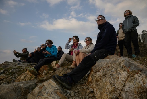 Des personnes observent la Lune passer devant le disque solaire lors d'une éclipse partielle, au sommet du Pic du Midi, le 12 août 2026 — Ed JONES / AFP