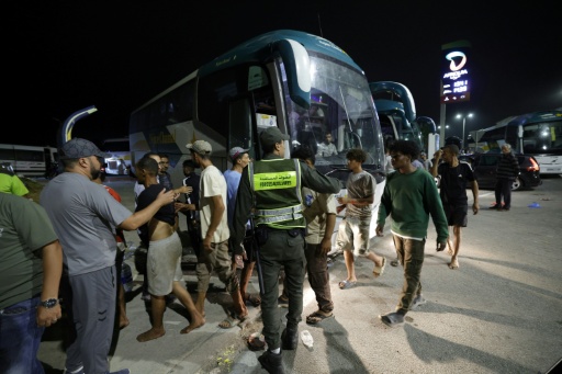 Des membres des forces de l'ordre marocaines acheminent par bus vers leurs villes d'origine des personnes qui avaient pénétré illégalement dans l'enclave espagnole de Ceuta, sur la côte nord du Maroc, le 1er août 2026 à Fnideq — Abdel Majid BZIOUAT / AFP