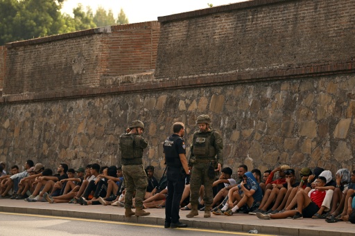 Des militaires espagnols et un policier devant des migrants qui étaient entrés illégalement dans l'enclave espagnole de Ceuta et qui sont peu à peu renvoyés au Maroc, le 1er août 2026 à Ceuta — JORGE GUERRERO / AFP