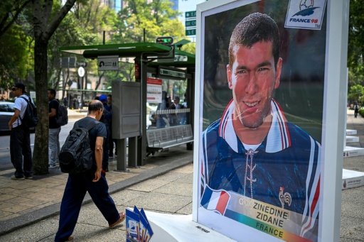 Un homme marche près d'une photo de l'ancien footballeur français Zinedine Zidane, lors d'une exposition consacrée à l'album Panini de la Coupe du monde, sur l'avenue Reforma à Mexico, le 11 mai 2026 — Alfredo ESTRELLA / AFP