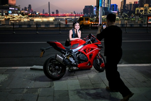 Bikers in China's Chongqing offer packages of choreographed photos and videos, cruising past the city's landmarks — WANG Zhao / AFP