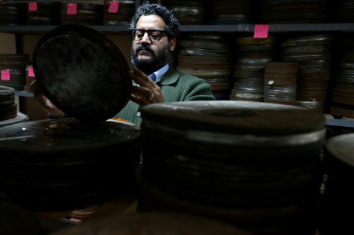 العضو في اللجنة العليا لـ"مبادرة دعم السينما" ومدير "سينماتيك العراق" وارث كويش يعاين علب أفلام سينمائية في بغداد في الخامس من شباط/فبراير 2026