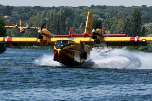 Un Canadair CL-415 de la Sécurité civile effectue des manœuvres d'écopage au-dessus de la Seine à Chartrettes, pour lutter contre un incendie dans la forêt de Fontainebleau, le 13 juillet 2026 en Seine-et-Marne — Thomas SAMSON / AFP