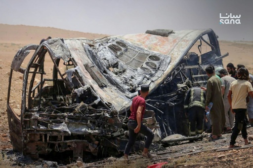 Cette photo prise et diffusée par l’agence de presse officielle syrienne SANA le 25 juillet 2026 montre des personnes et des secouristes inspectant les dégâts sur les lieux de la collision meurtrière entre deux bus sur la route reliant Damas à Deir Ezzor — - / AFP