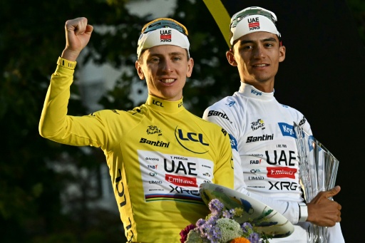 El ciclista esloveno Tadej Pogacar, del equipo UAE Team Emirates XRG, con el maillot amarillo de líder de la clasificación general, y mexicano Isaac Del Toro, del mismo equipo, con el maillot blanco de mejor joven, celebran en el podio tras la 21.ª etapa de la 113.ª edición del Tour de Francia, una carrera de 88,7 km con salida y llegada en París, el 26 de julio de 2026 — Loic VENANCE / AFP