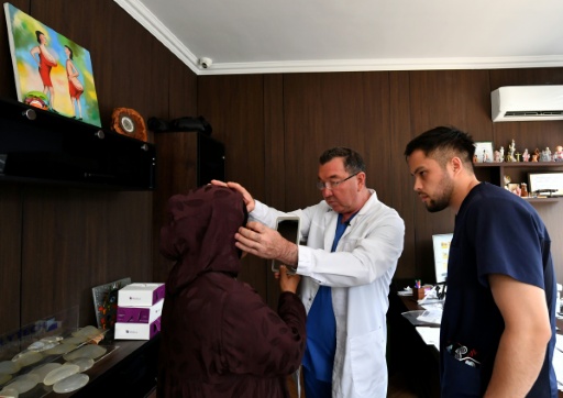 Le chirurgien esthétique Iskender Katchkinbaïev examine une patiente à Bichkek, le 18 mai 2026 au Kirzghizstan — Vyacheslav OSELEDKO / AFP