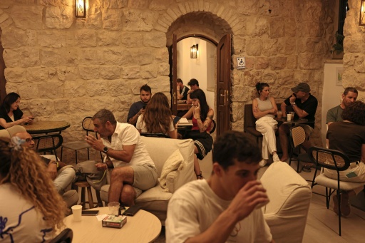 Varios israelíes toman café en la cafetería Basimta de Jerusalén, pese a ser día de shabat, el 15 de agosto de 2026 — AHMAD GHARABLI / AFP
