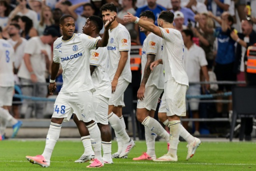 Le jeune Marseillais Keyliane Abdallah célèbre son but avec ses coéquipiers de l'OM lors du match d'ouverture de la 1re journée de Ligue 1 entre l'Olympique de Marseille et Strasbourg au stade Vélodrome le 21 août 2026 — Pascal POCHARD-CASABIANCA / AFP