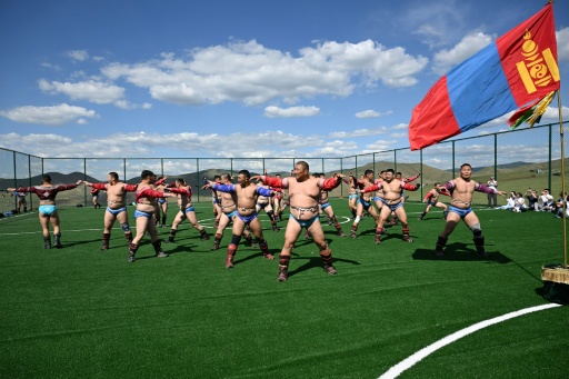 Cette photo prise le 24 juin 2026 montre des lutteurs mongols exécutant une danse lors d'un camp d'entraînement en vue du festival de Naadam, en périphérie d'Oulan-Bator.
