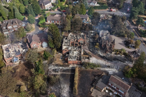 De la fumée s'élève de maisons endommagées par un incendie, au sud de Stourbridge, dans le centre de l'Angleterre, le 14 août 2026 — Darren Staples / AFP