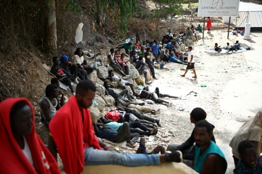 Crowds of migrants - pictured here on August 1, 2026 - slept rough outside Ceuta's full migrant centre — Henry Nicholls / AFP
