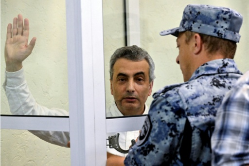 Un huissier passe les menottes à Lev Chlosberg, vice-président du parti antiguerre russe Iabloko, condamné à 11 ans de prison pour avoir critiqué l'offensive de Moscou en Ukraine, au tribunal de Pskov, dans le nord-ouest de la Russie, le 17 août 2026 — Olga MALTSEVA / AFP