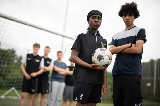 Fabian Myers (r) et Kaziah Cameron (2e d), élèves du collège-lycée public Our Lady and St Chad Catholic Academy et participants du programme "Football Beyond Borders" (FBB), après un match de foot avec d'autres élèves du programme à Wolverhampton, le 12 juin 2026 au Royaume-Uni