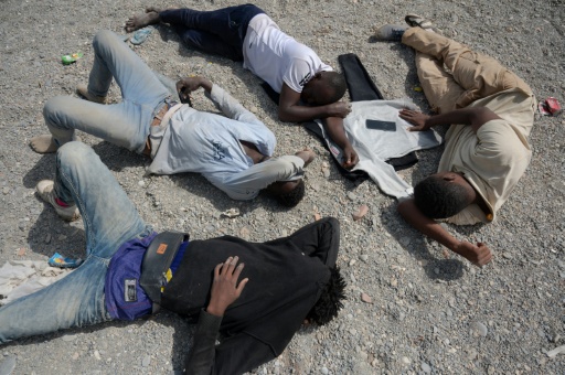 Unos migrantes permanecen en la playa Trampolín de la ciudad autónoma española de Ceuta el 1 de agosto de 2026, mientras esperan para entrar en el Centro de Estancia Temporal de Inmigrantes (CETI) — Jorge Guerrero / AFP