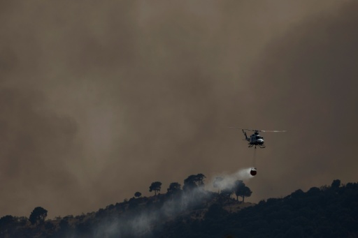 Un hélicoptère bombardier d’eau largue de l’eau sur un incendie de forêt près de Robledo de Chavela, à environ 60 kilomètres à l’ouest de Madrid, le 27 juillet 2026 — Oscar DEL POZO / AFP
