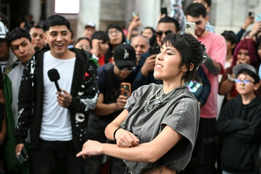 A young woman gestures during an "aura battle" in Mexico City, a viral trend where young people perform moves that convey coolness and charisma — Yuri CORTEZ / AFP