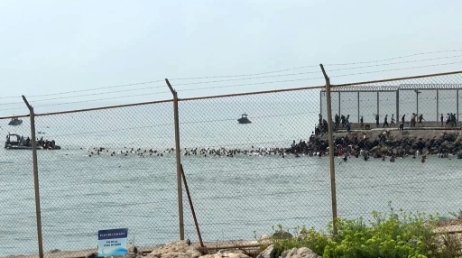 Des dizaines de personnes nagent pour tenter d'atteindre l'enclave espagnole de Ceuta depuis le Maroc, comme le montre cette capture d'écran d'une vidéo tournée par une journaliste de l'AFP, le 30 juillet 2026 — Lucía DIAZ / AFP