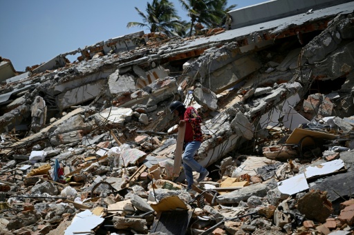 Una persona busca chatarra entre los escombros del edificio "La Mar Suite" en Tucacas, Venezuela, el 22 de julio de 2026, casi un mes después del mortal doble terremoto — Federico Parra / AFP