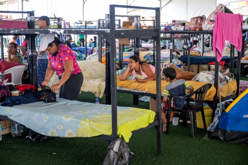 People displaced by Venezuela's June 24, 2026 earthquakes rest on bunk beds inside a temporary shelter set up at a sports complex in La Guaira state, the epicenter of the disaster