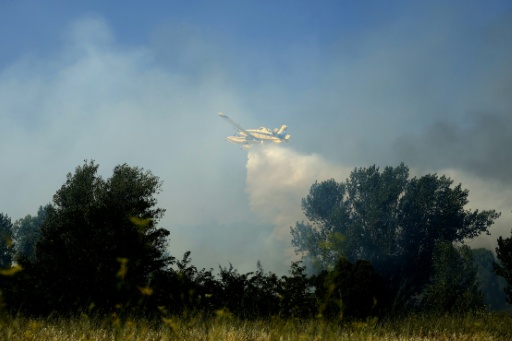 Un avión combate el incendio declarado en una zona industrial de la localidad española de San Martín de Valdeiglesias, a unos 70 kilómetros al oeste de Madrid, el 26 de julio de 2026 — Óscar del Pozo / AFP