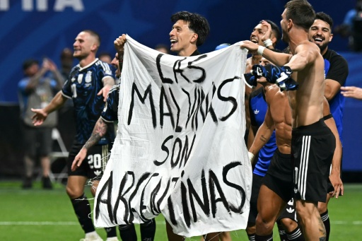 Argentina's players hold a banner reading "The Falklands are Argentine — Paul ELLIS / AFP