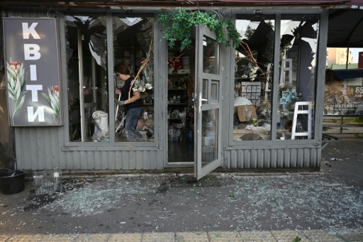 Une employée nettoie une boutique de fleur, dont le sol est recouvert de débris, à la suite d'une frappe de missile russe le 1er août 2026 à Kiev — Genya Savilov / AFP