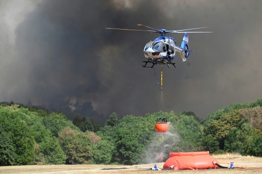 A police helicopter loads water to fight a forest fire in Huertgenwald, western Germany on August 14, 2026 — Roberto Pfeil / AFP