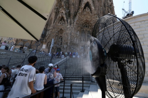 Un ventilador humidificaor para refrescar a los visitantes de la Sagrada Familia funciona frente al célebre templo, el 7 de julio de 2026 en la ciudad española de Barcelona