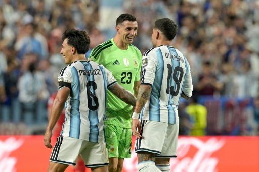 مدافع منتخب الأرجنتين ليساندرو مارتينيس (#6) وحارس مرماه إيميليانو مارتينيس (#23) ومدافعه نيكولاس أوتامندي (#19) يحتفلون بالهدف الثالث في مرمى سويسرا في ربع نهائي كأس العالم 2026 لكرة القدم. ملعب كانساس سيتي، كانساس سيتي. في 11 تموز/يوليو 2026.