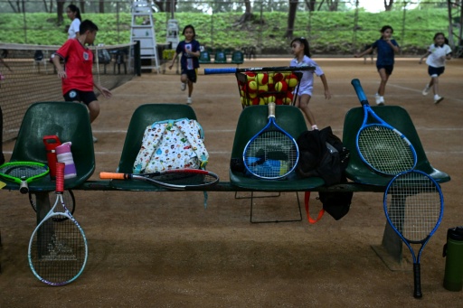 Tennis racquets on a bench as children take part in training in Metro Manila — Jam STA ROSA / AFP