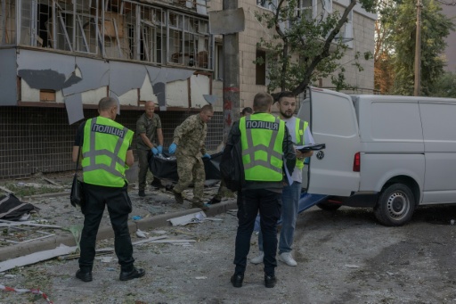 Le corps d'une victime est transporté dans un van à côté d'un immeuble résidentiel endommagé à la suite d'une frappe russe à Kiev, le 20 août 2026 — Roman PILIPEY / AFP
